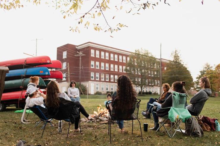 白天，九名博彩app推荐的学生围坐在户外的火堆旁
